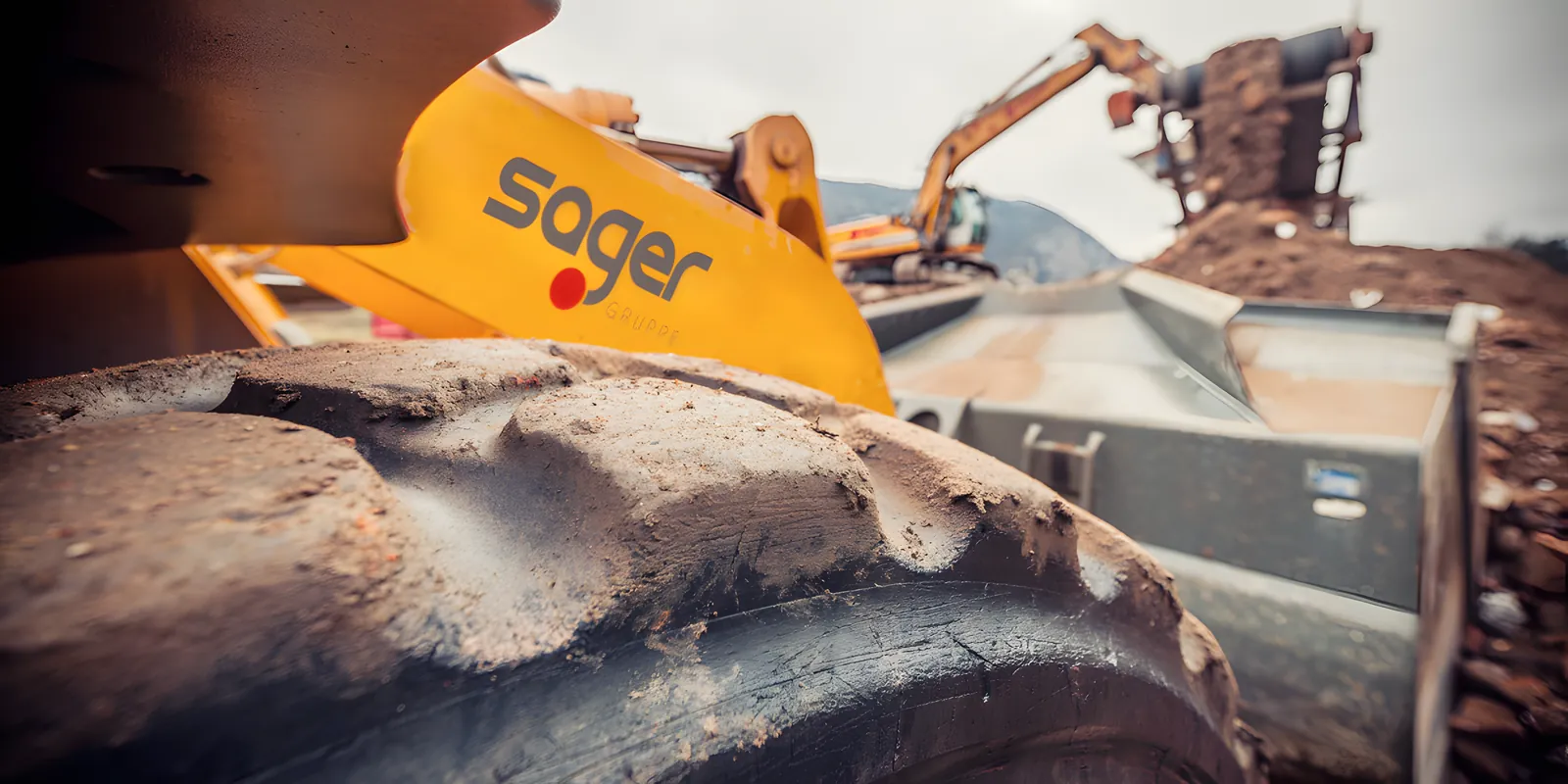 Baggerschaufel mit Sager-Logo auf der Baustelle
